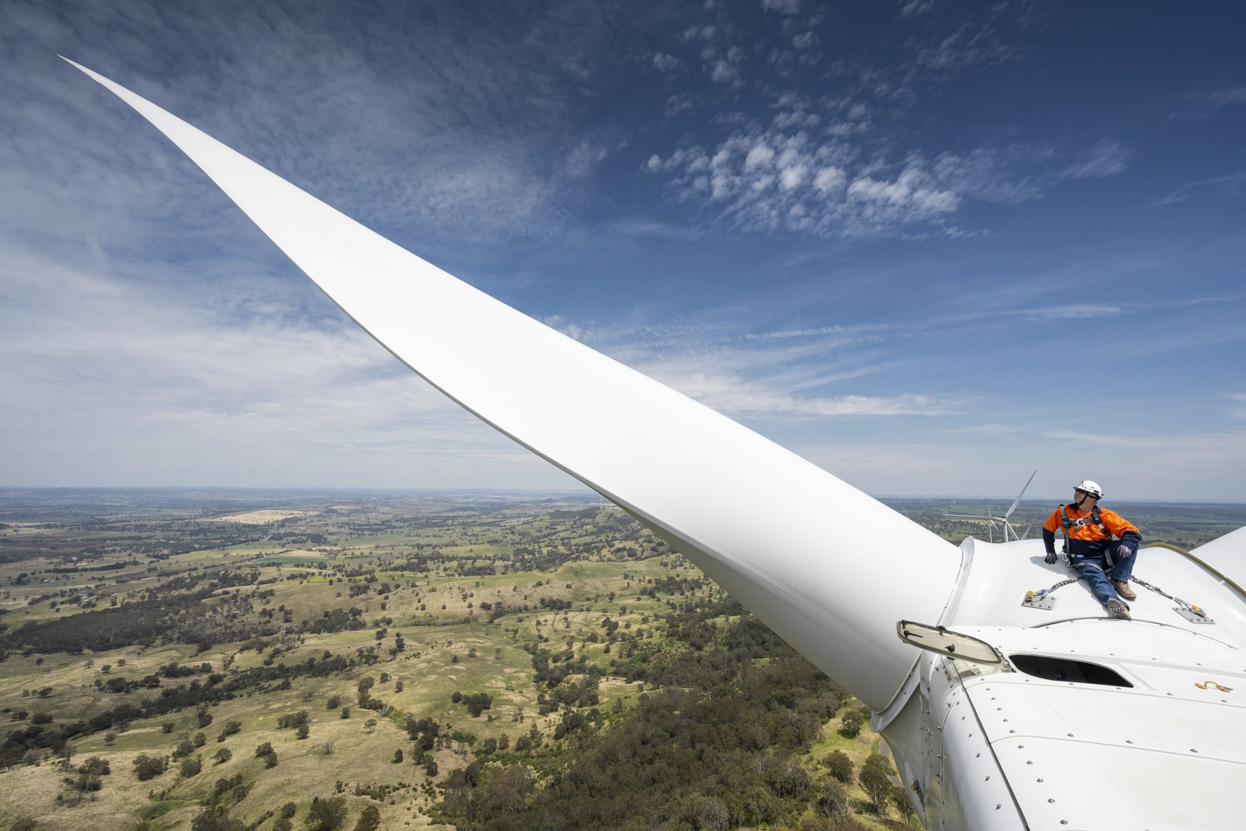 Industrial Photography in engineer sitting on top of a wind turbine Industrial Photography in engineer sitting on top of a wind turbine